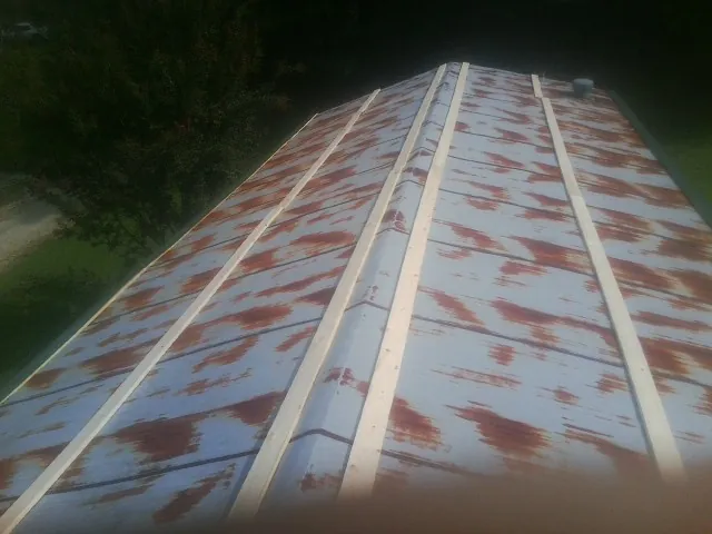 Rusted metal roof panels with new wood purlins before replacement — Storm Damage Roof Repair in Loreauville by Roofing Brothers