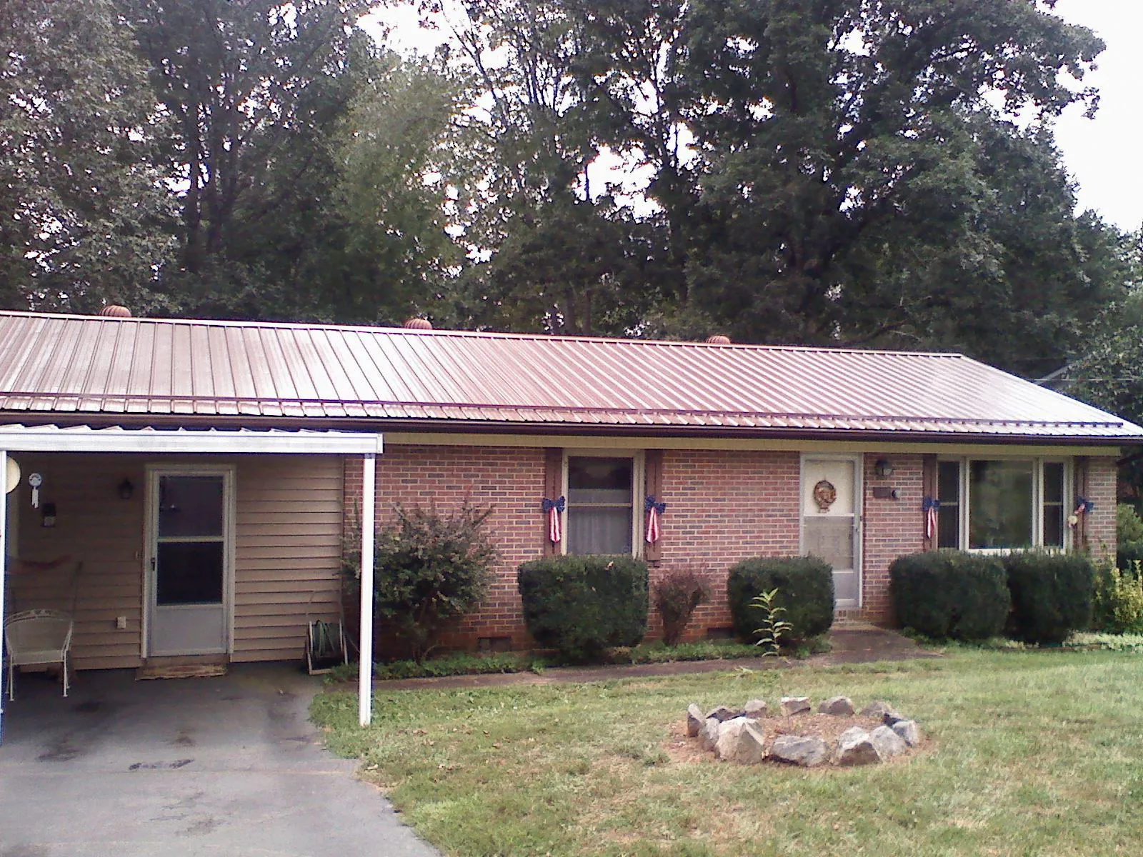 Bronze metal roof and carport on a brick ranch home — Roof Repair work by our crew in Loreauville