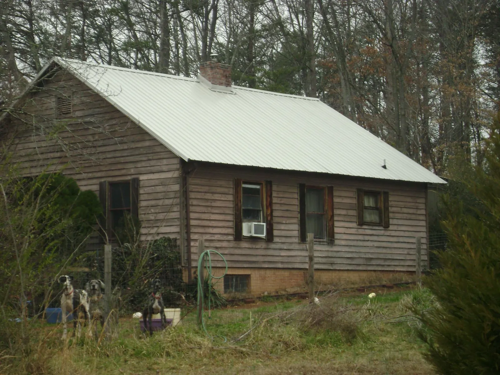 White metal roof on an old wood sided farmhouse, from a Asphalt Shingle Roof Repair job in Loreauville